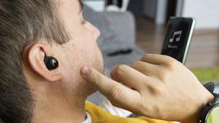 Noin 40-vuotias mies kuunteli kännykästä musiikkia Bluetooth-korvanappikuulokkeilla
